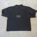 A grey garment dye short-sleeve t-shirt with a small white and gold 'Hiplé' logo printed on the chest, laid flat on a textured beige fabric background. By the brand Hiplé (Hiple)
